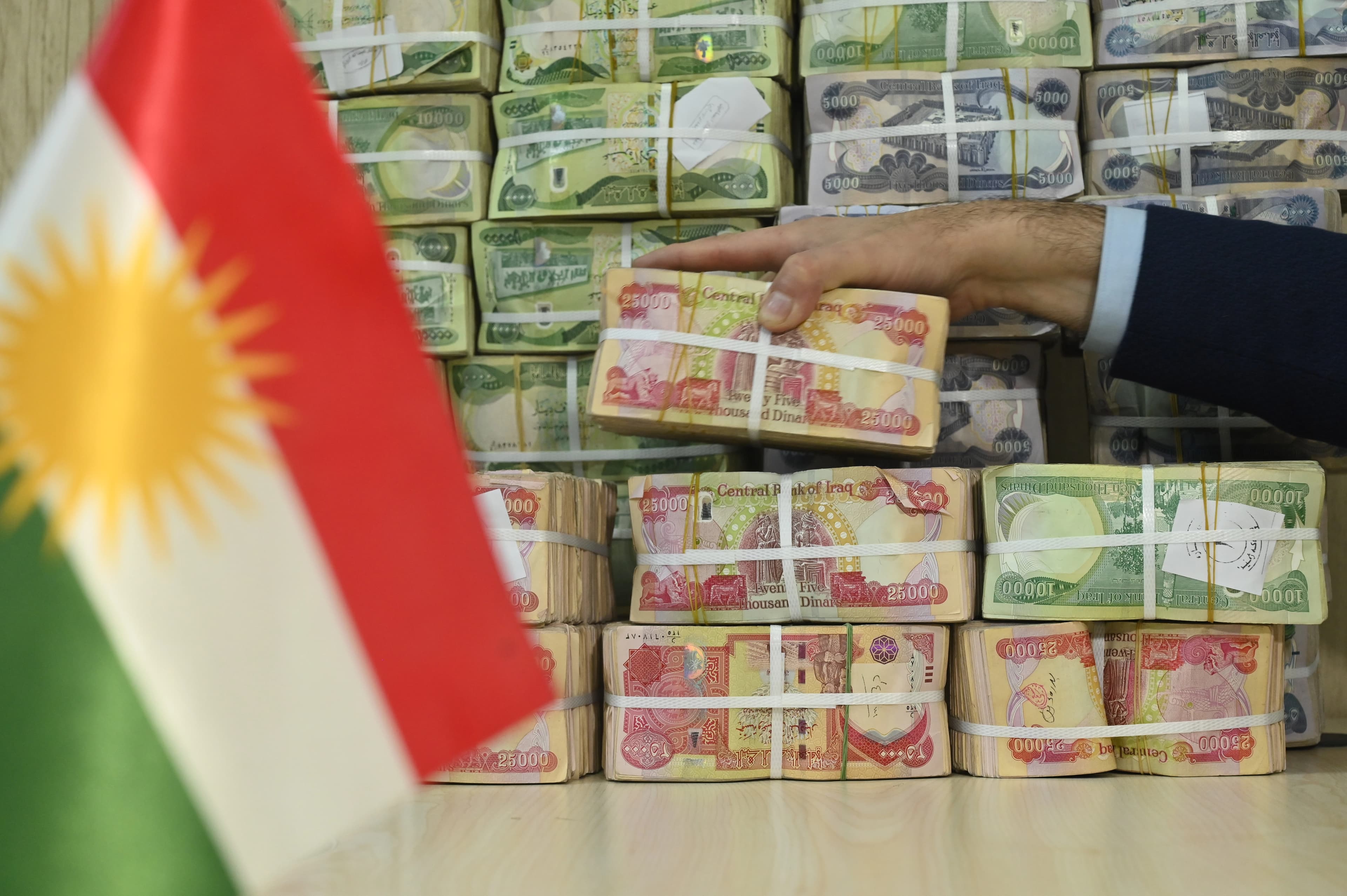 Kurdistan Region's flag and stacks of Iraqi dinar banknotes. Photo: Bilind T. Abdullah/ Rudaw